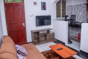 a living room with a couch and a tv and a table at Rainbow apartment in Mombasa