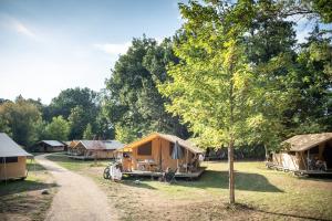 a group of tents in a field with a tree at CityKamp Strasbourg in Strasbourg