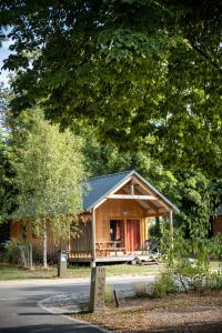 a log cabin with a porch and a tree at CityKamp Strasbourg in Strasbourg