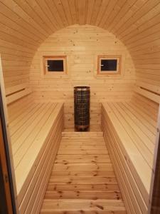a wooden sauna with a heater in the middle at Ferienhaus mit Sauna für romantische Zweisamkeit in Molbergen