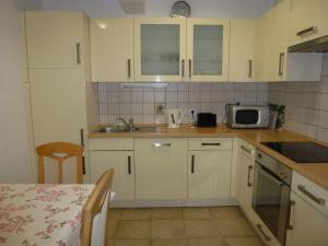 a kitchen with white cabinets and a sink and a microwave at Apartment Jalps 2 in Bohinj