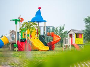 a playground with colorful slides and a play structure at Morena house in Niechorze