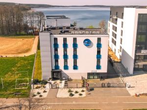 - une vue sur un bâtiment blanc doté de fenêtres bleues dans l'établissement Apartament 101 Aquarius Boszkowo, à Boszkowo