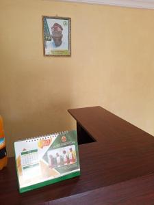 ein Buch, das auf einem Holztisch neben einem Tisch sitzt in der Unterkunft Greendale apartment and Lodge in Ibadan