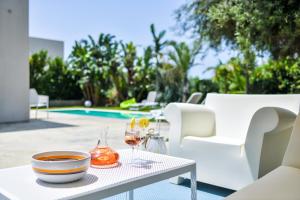 een tafel met twee glazen wijn op een patio bij Villa Ponente - Design House with Private Pool in Marina di Ragusa