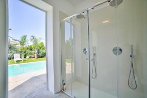 een glazen douche in een badkamer met een zwembad bij Villa Ponente - Design House with Private Pool in Marina di Ragusa