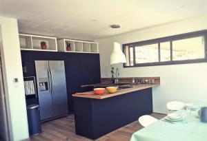 een keuken met blauwe kasten en een roestvrijstalen koelkast bij JOIA in Saint-Raphaël