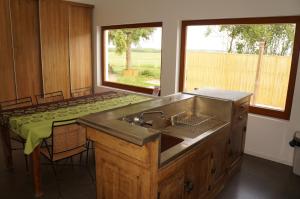 eine Küche mit einer Spüle aus Edelstahl und einem Fenster in der Unterkunft Maison Le Corbusier in Doncourt-lès-Conflans