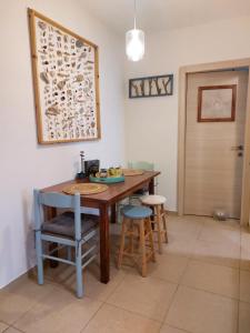 eine Küche mit einem Tisch, Stühlen und einer Tür in der Unterkunft צמח בר in Midreshet Ben Gurion