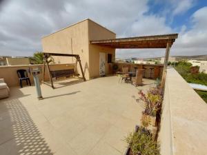 un patio con mesa y sillas en la azotea en צמח בר, en Midreshet Ben Gurion