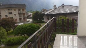 a balcony with a wooden fence and a house at Casa Lina in Novate Mezzola
