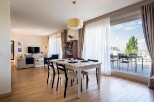 a dining room and living room with a table and chairs at Marina di Scarlino Resort in Puntone di Scarlino