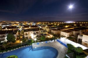 a view of a city at night with a pool at Lighthouse Parquemar in La Mata