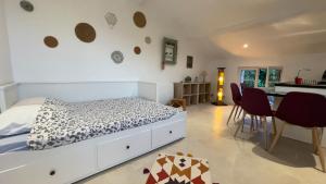 a bedroom with a white bed and a kitchen at DUPLEX - VALBONNE VILLAGE in Valbonne
