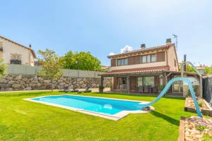 un patio trasero con piscina y una casa en Casa Valdizarbe, espaciosa casa rural próxima a Pamplona en Biurrun