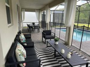 ein Wohnzimmer mit einem Sofa, einem Tisch und einem Pool in der Unterkunft Elegant Luxury Villa Movie Room Private Pool in Kissimmee