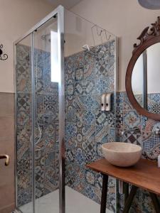 uma casa de banho com um chuveiro, um lavatório e um espelho. em Villa Rosa Candida em San Foca