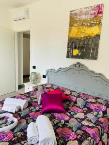 un letto con cuscini rosa e asciugamani di Appartamenti Podere San Sebastiano a Castiglione della Pescaia