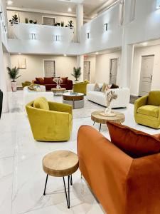 a large living room with yellow and white furniture at Hotel Aluxor SFO, Sapphire Boutique Collection in San Bruno