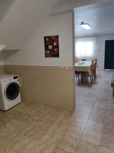 a living room with a washing machine and a table at HOUSEMARIA in Nazaré