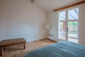 a bedroom with a bed and a table and a window at Villa Domaine du golf de Roquebrune in Roquebrune-sur-Argens +26 photos