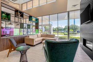 a living room with a couch and a tv at Holiday Inn Orlando International Dr-ICON by IHG in Orlando