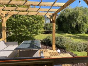 a wooden pergola with a table and a ping at Willow Lodge , Corskie Drive Macduff-Banff in Macduff