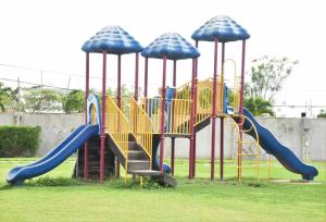 a playground with a slide in a park at Cozy and Secure Jacaranda Home in Spanish Town