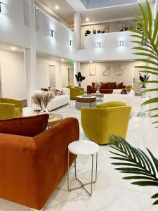 un vestíbulo con sofás, sillas y plantas en Hotel Aluxor SFO, Sapphire Boutique Collection, en San Bruno
