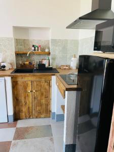 una cucina con armadi in legno e frigorifero nero di Appartamenti Podere San Sebastiano a Castiglione della Pescaia