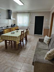 a kitchen and living room with a table and a couch at HOUSEMARIA in Nazaré