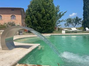 uma fonte de água numa piscina num quintal em Casavacanze Casalta em Sovicille