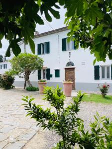 una casa bianca con persiane verdi di Appartamenti Podere San Sebastiano a Castiglione della Pescaia