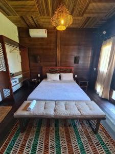 ein Schlafzimmer mit einem großen Bett in einem Holzzimmer in der Unterkunft Atins Charme Chalés in Atins