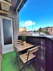 a wooden table and bench on a balcony with a window at LG DownTown Sabadell Apartment in Sabadell