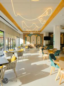 une salle à manger avec des tables et des chaises et un plafond dans l'établissement Merar Hotel, à Golem