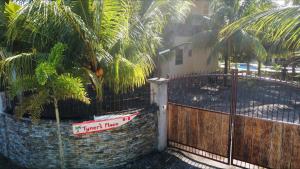 a fence with a sign on it next to a house at Tyner's Place in Panglao