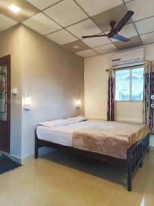 a bedroom with a large bed with a ceiling fan at White Shore Beach Homestay in Alleppey