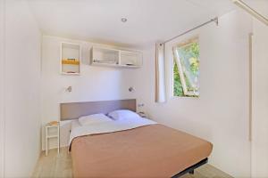 biała sypialnia z łóżkiem i oknem w obiekcie CityKamp Strasbourg w Strasburgu