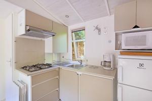 a small kitchen with a stove and a microwave at CityKamp Strasbourg in Strasbourg