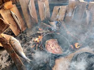 a piece of meat cooking in a pot on a grill at Kyst- og Fjordcentret in Ørsted
