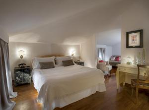 a bedroom with a white bed and a living room at La Villa in Siena