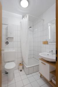 een witte badkamer met een toilet en een wastafel bij MINT: Design Studio – Parken – Küche – WiFi in Dortmund