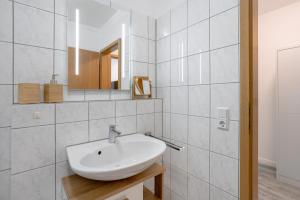 een witte badkamer met een wastafel en een spiegel bij MINT: Design Studio – Parken – Küche – WiFi in Dortmund