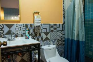 a bathroom with a toilet and a sink and a mirror at Mala Vecindad Centro Historico in Mexico City
