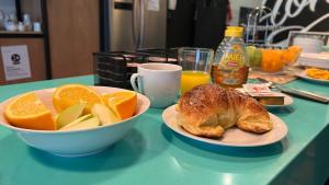 a table with two plates of fruit and a croissant and oranges at Viajero Montevideo Hostel in Montevideo +47 photos