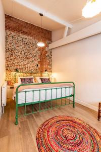 a bedroom with a bed and a brick wall at Nicholson Cottage in Happisburgh