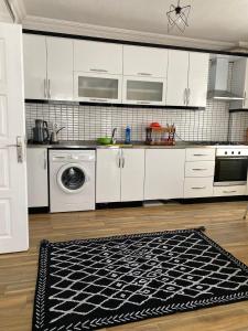 a kitchen with white cabinets and a black and white rug at KAŞ MERKEZ İMREN APART 1 in Kas