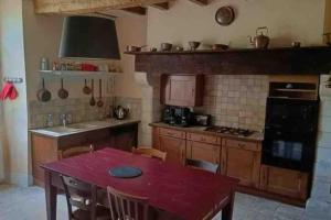 a kitchen with a red table and a kitchen with a stove at Maison de maître avec piscine in Lombers +10 photos