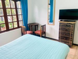 1 dormitorio con 1 cama y TV de pantalla plana en Hostel Costa Morena, en Constitución